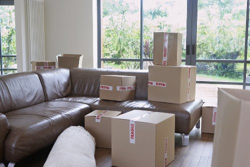 Professional movers carrying furniture through a Docklands apartment corridor